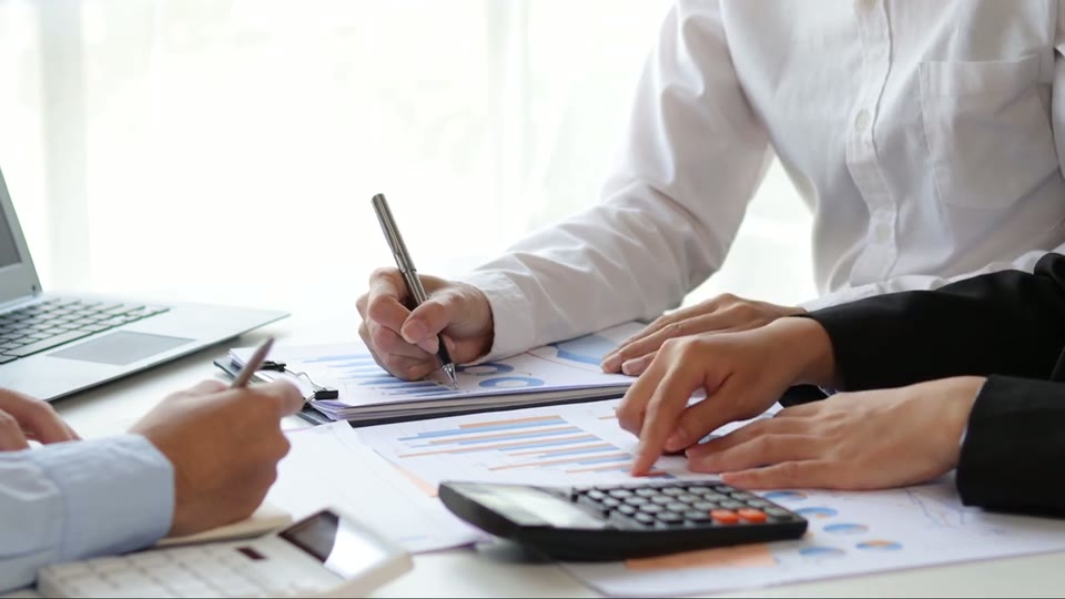 A report being signed, pen in hand, after it was gone through together
