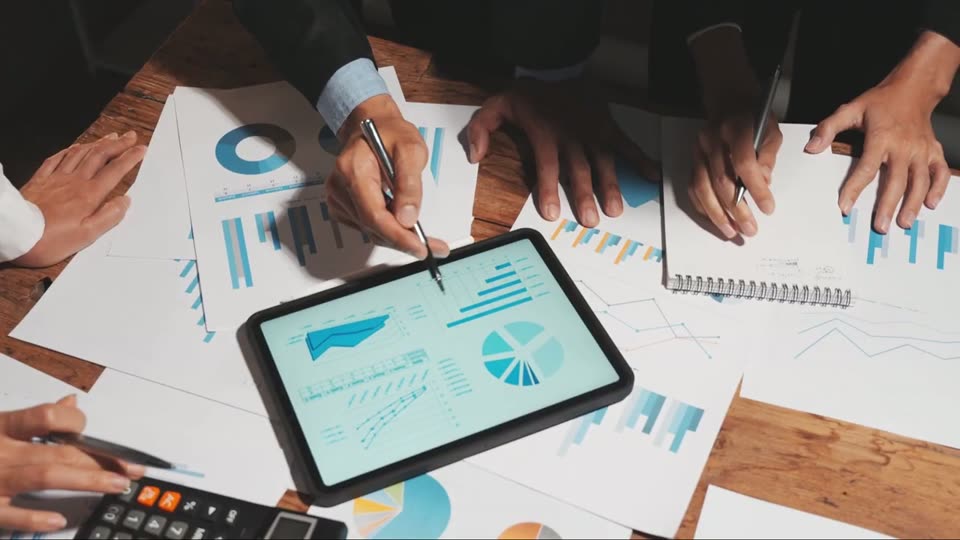Hands going through charts on a tablet and on paper