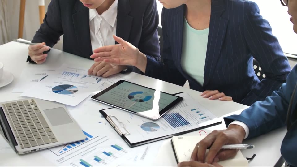Colleagues reviewing financial reports around a table